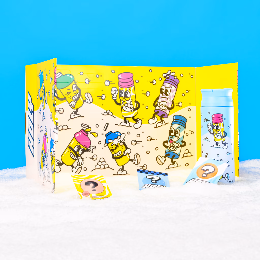 The yellow calendar folded open on snow with the thermo shaker and sachets in front