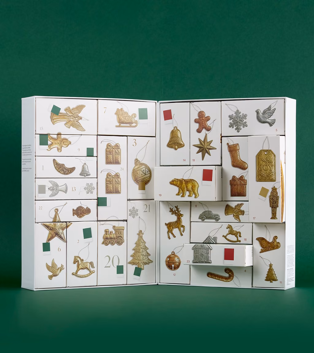 The 24 boxes reassembled into their puzzle scenes with the gold and silver ornaments