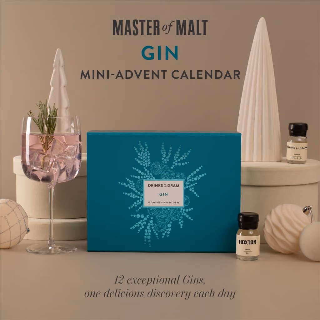 The teal mini box on a beige set beside a gin glass and a dram