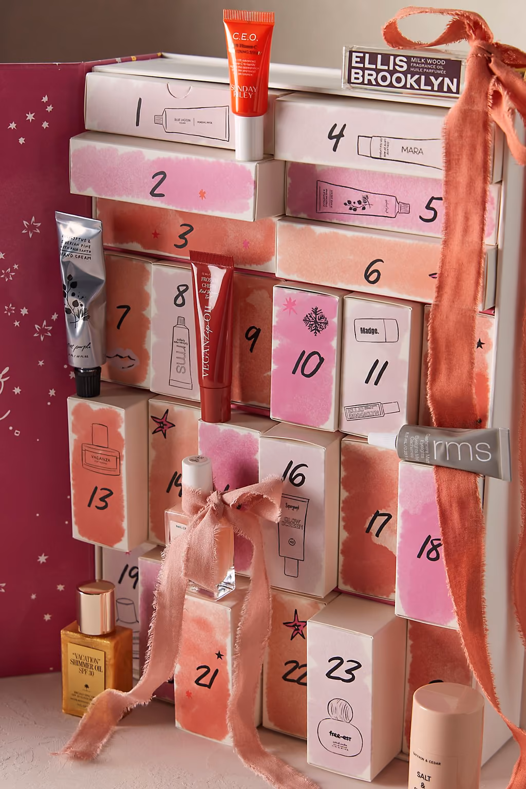 The Free People calendar open, its numbered drawers holding lip oil, mascara, hand cream and small bottles