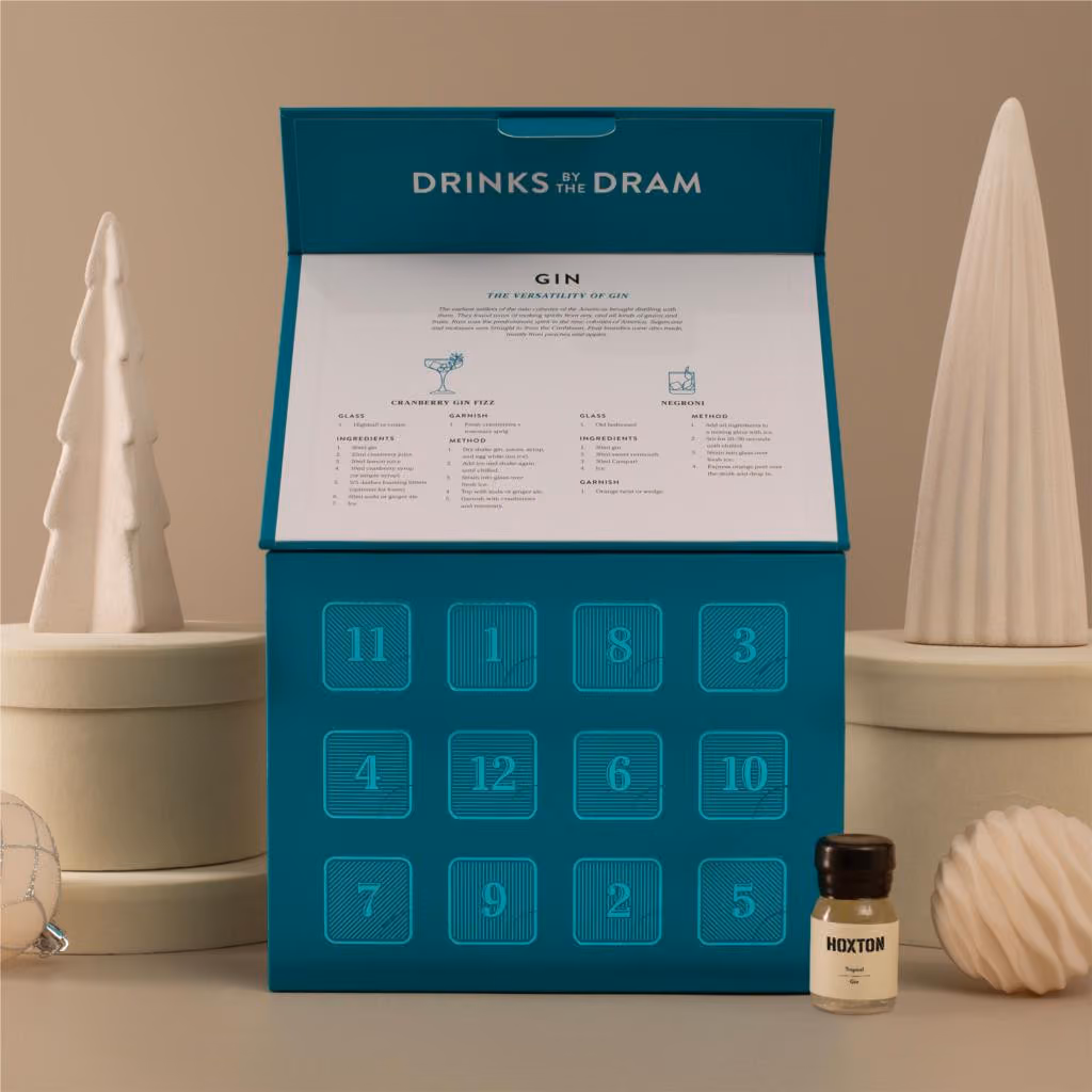 The box with its lid raised over 12 numbered doors and a gin guide