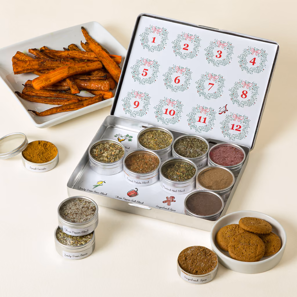 The open tin with spice tins, roasted carrots and gingerbread cookies beside it