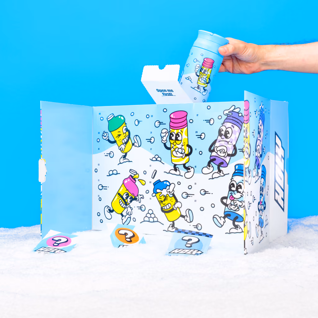 The blue calendar folded open on snow, a hand lifting the thermo shaker out of it