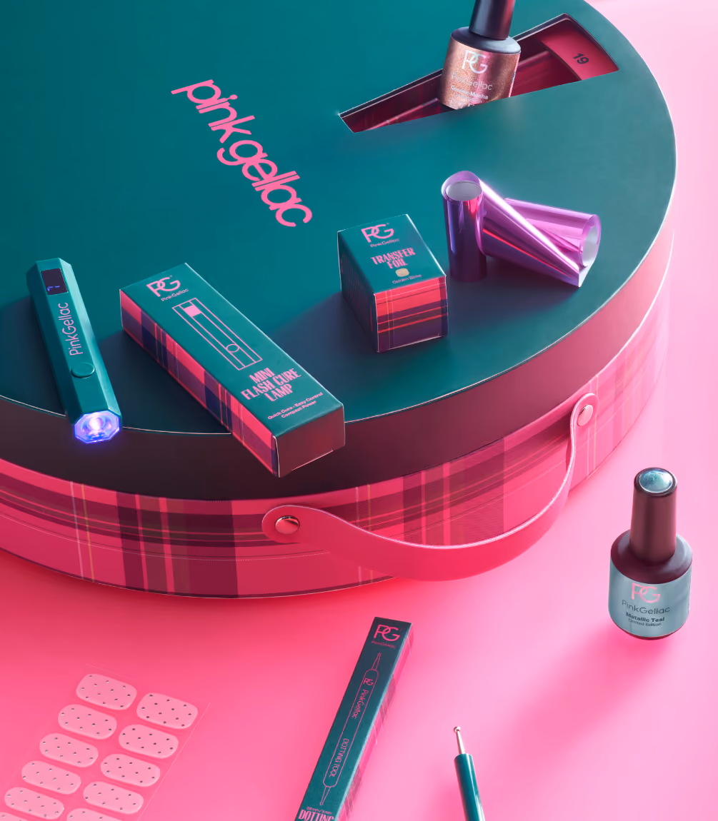 The lid off, bottles and nail stickers on the pink tartan