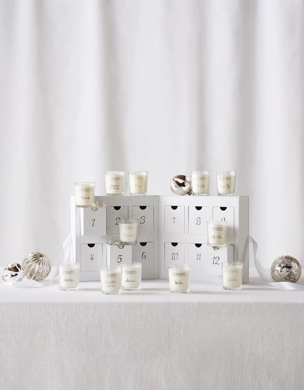 The twelve-drawer box open with the votive candles standing on and around it