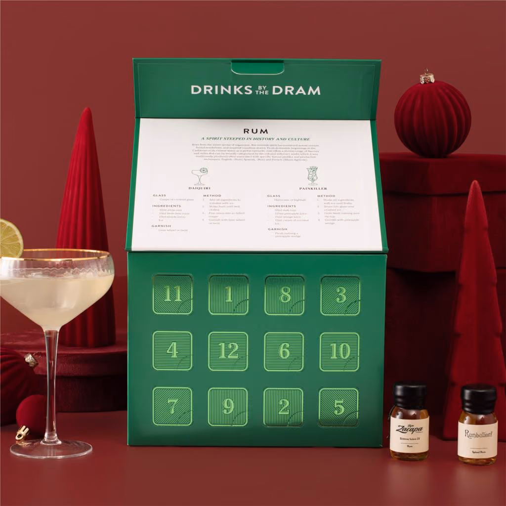 The box with its lid raised over 12 numbered doors and a rum guide