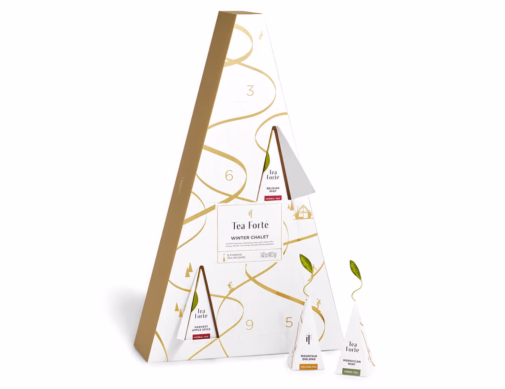 The Winter Chalet advent with two doors open and two pyramid infusers standing beside the box