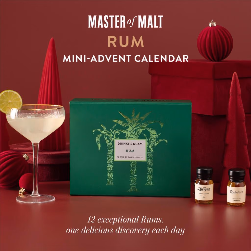 The green palm-printed mini box on a red set beside a daiquiri and two drams