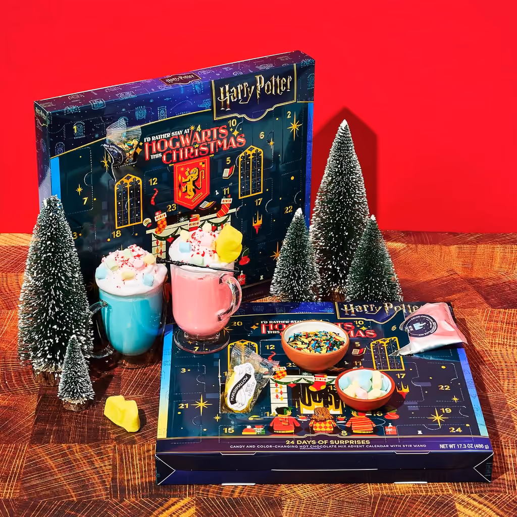 Two finished hot chocolates beside the box and an open tray of toppings