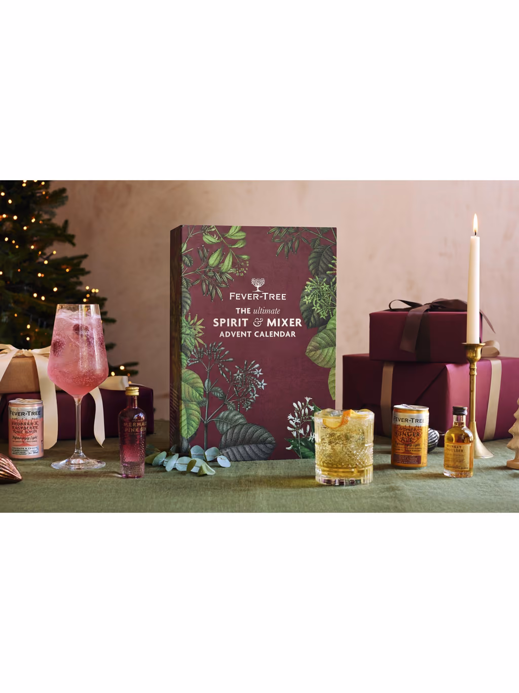The closed calendar by a Christmas tree with two mixed drinks