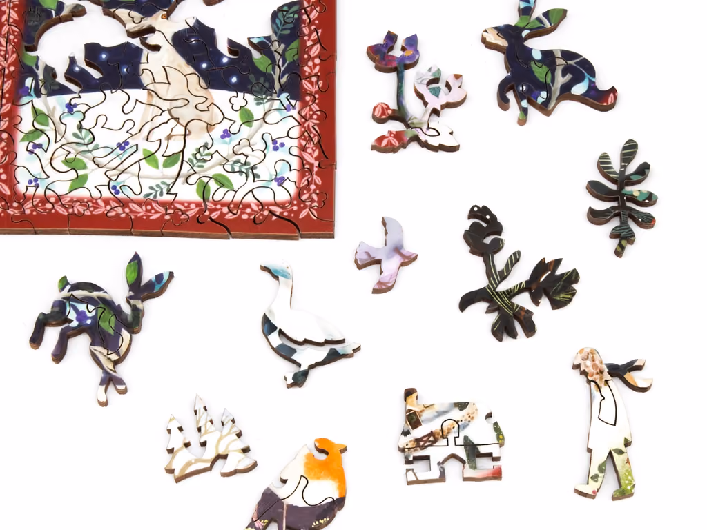 Whimsy-shaped wooden pieces of birds and foliage beside an assembled section