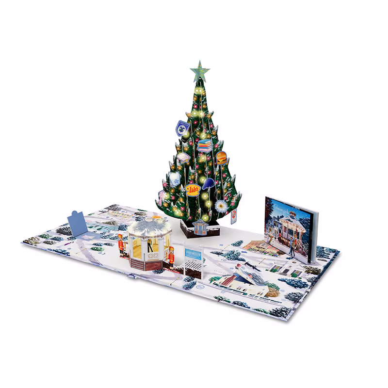 The calendar open into a pop-up Stars Hollow, the lit tree hung with printed ornaments beside the gazebo