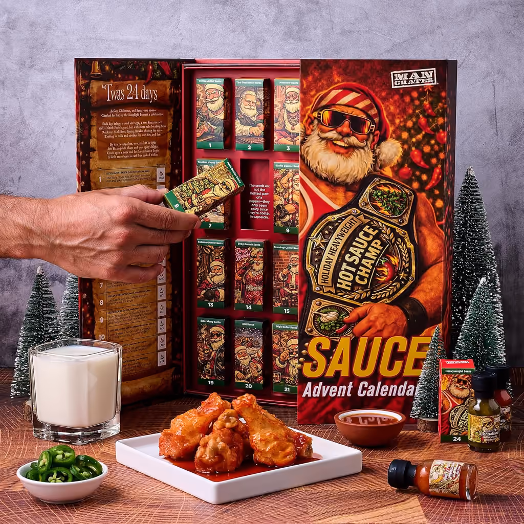 A hand pulling a carton from the open box beside a plate of wings