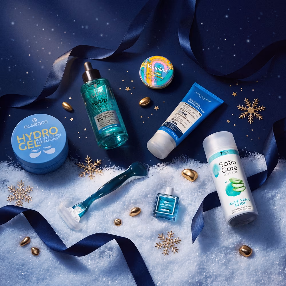 Eye gel patches, a razor, a hair oil and a deodorant on snow