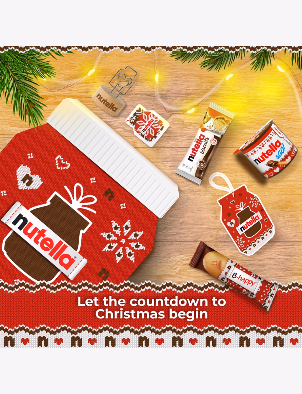 The box lying on a wooden table with the snacks, a tree hanger and the photo holder around it