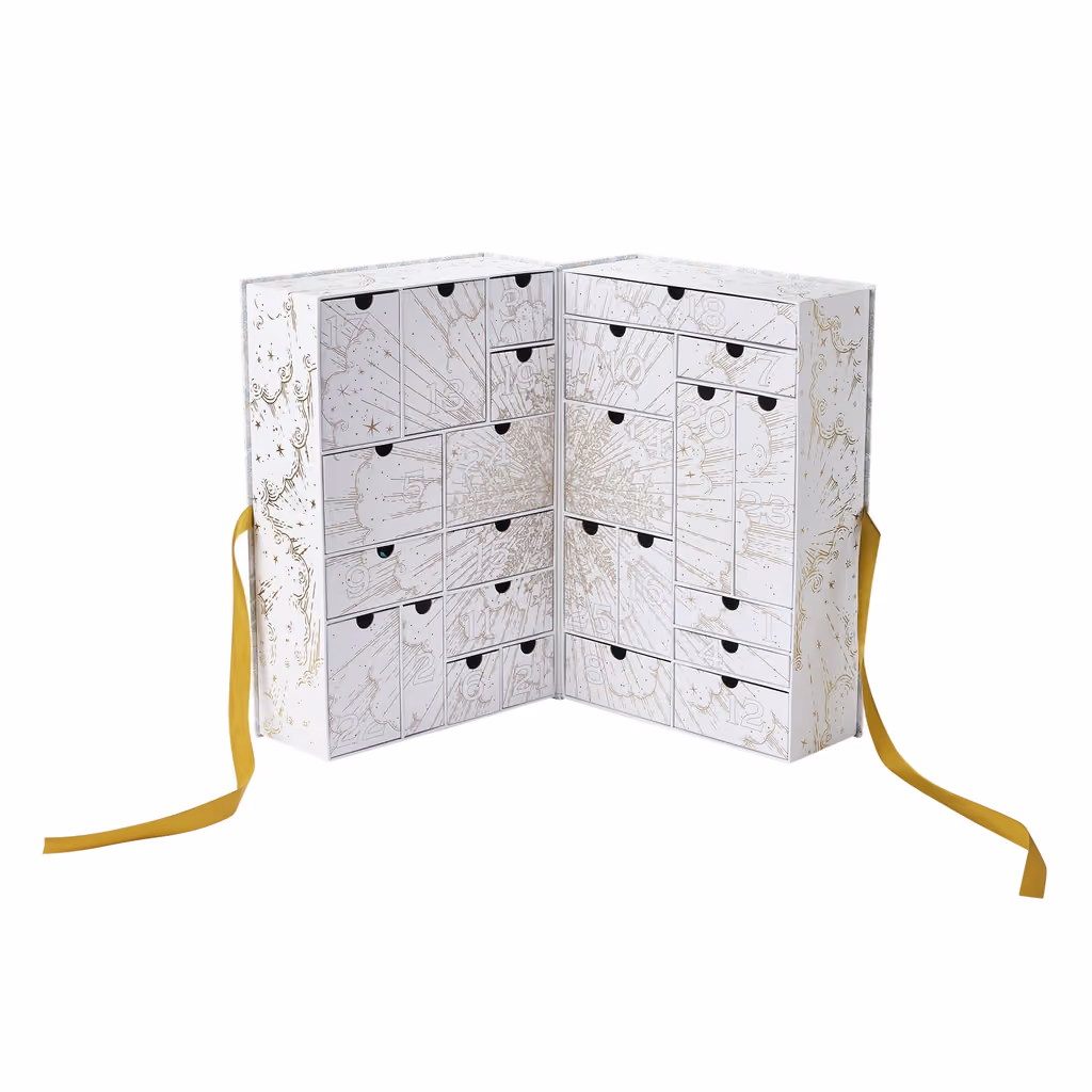 The white and gold box open and empty, its 25 numbered drawers showing
