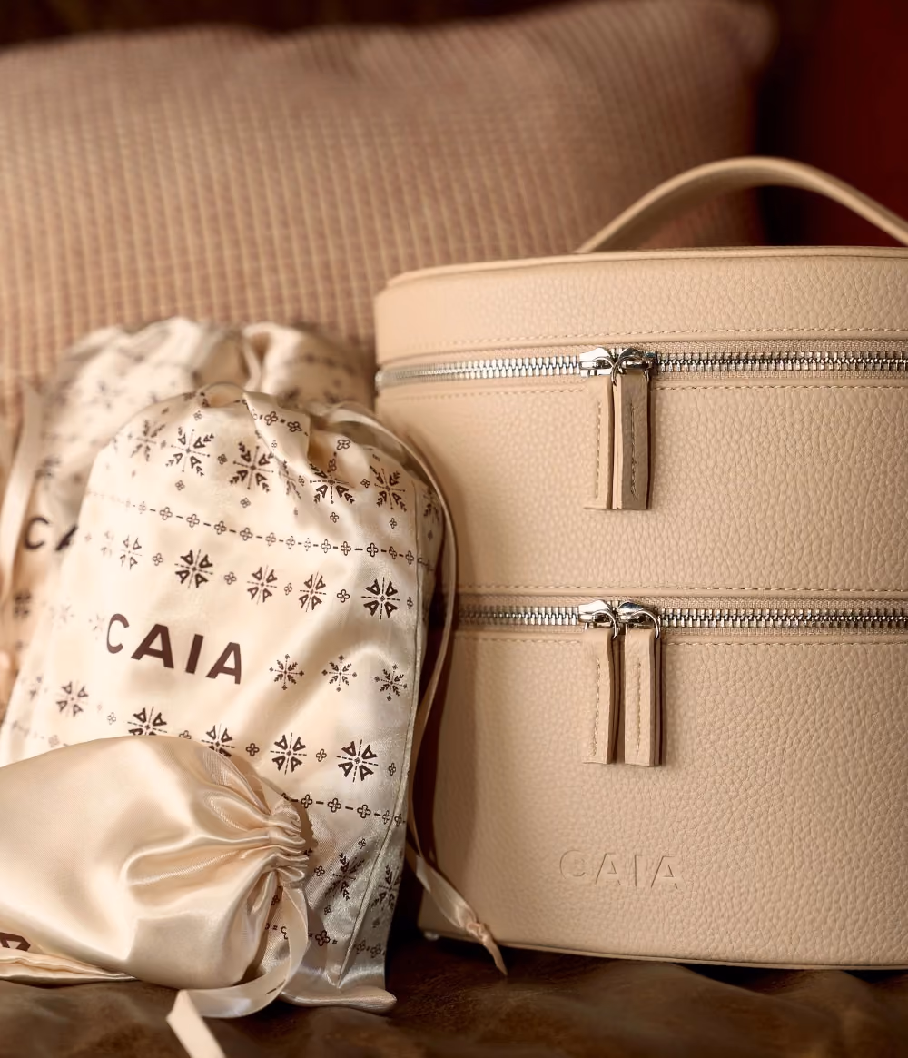 The CAIA beauty case beside a patterned drawstring bag and a satin pouch