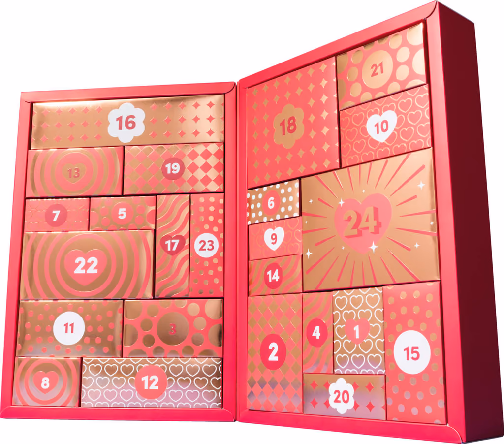 The box open flat with its 24 numbered pink and gold drawers still shut