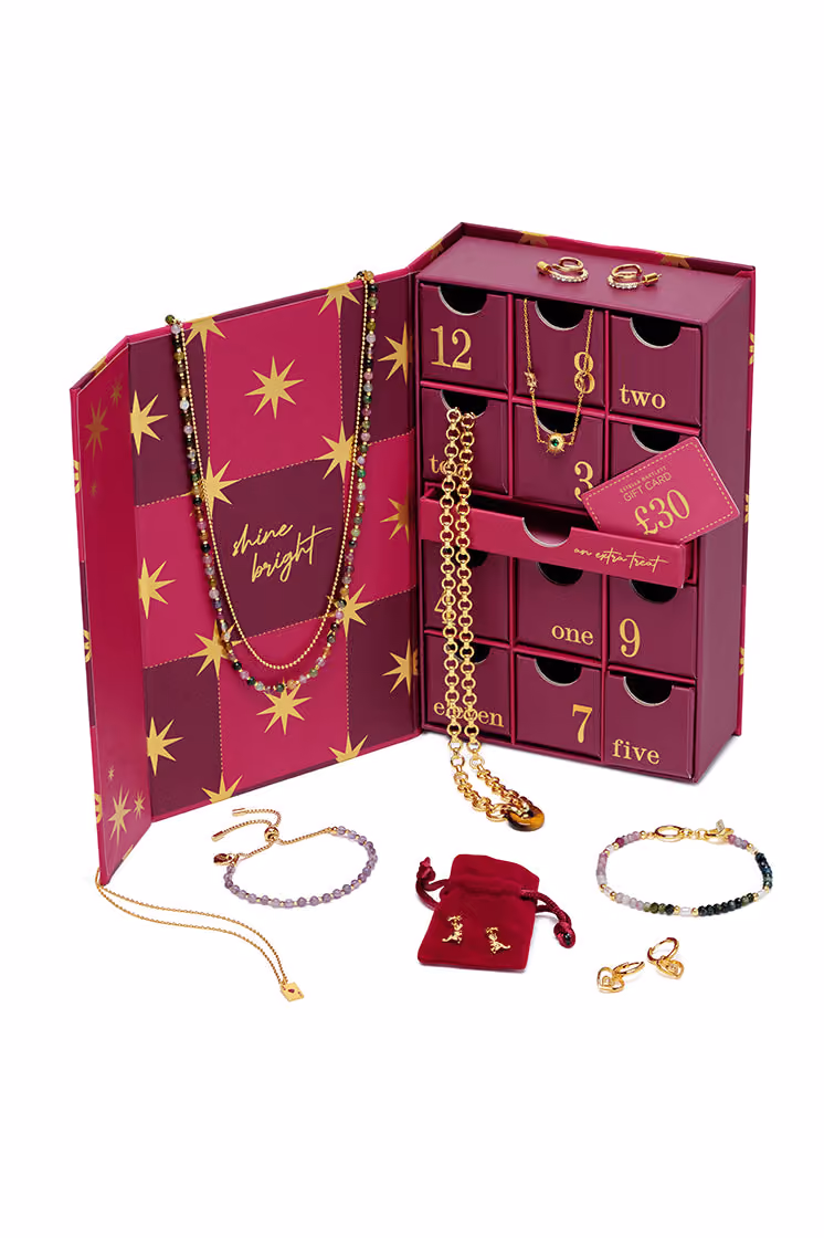 The gold necklaces, bracelets and earrings laid out around the open box