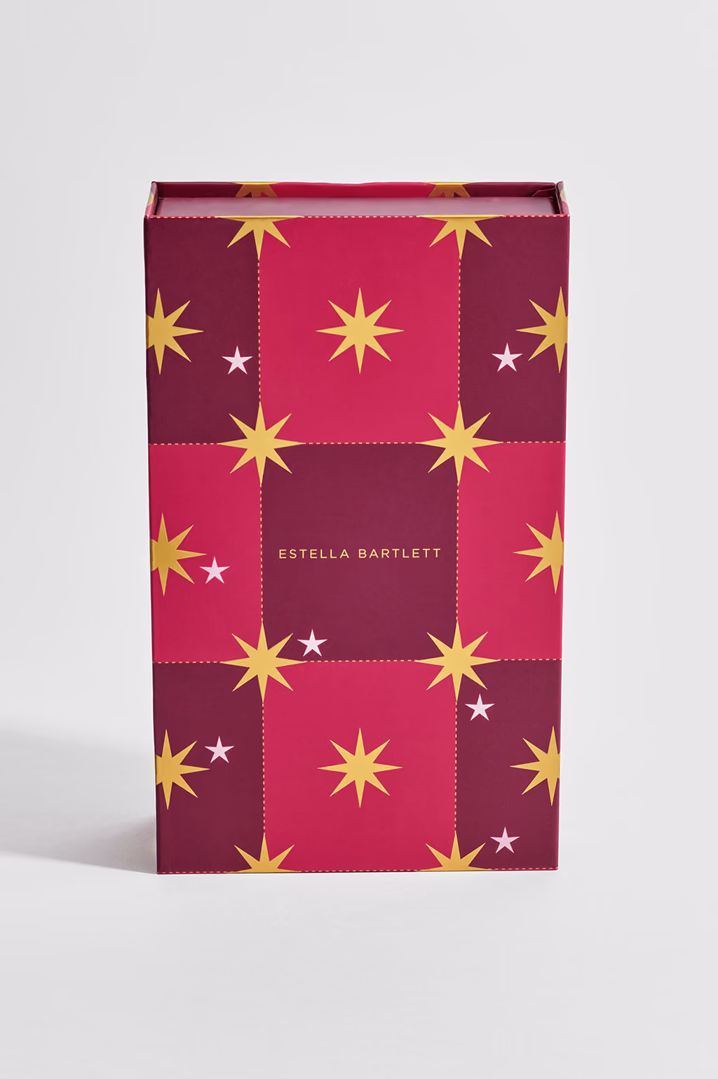 The closed box face on, gold stars on magenta and plum checks