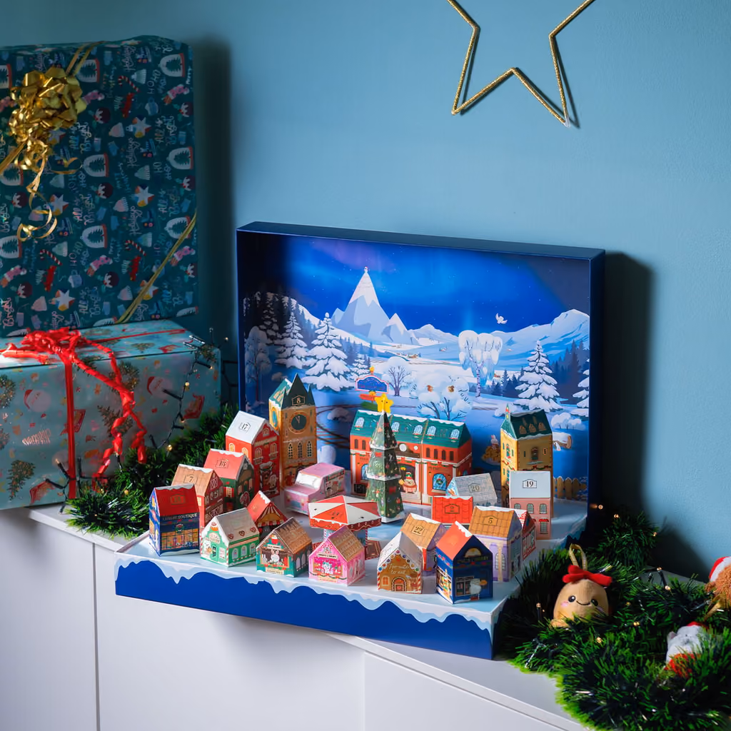 The Dream Peaks village on a sideboard among wrapped presents