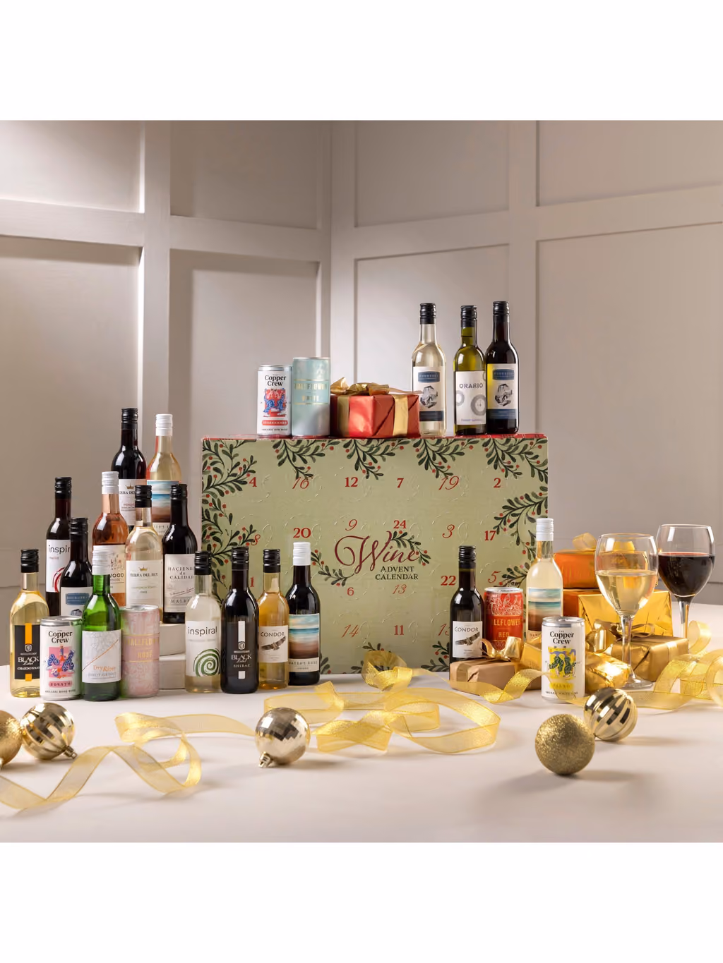 The box on a table with bottles, glasses and gold ribbon