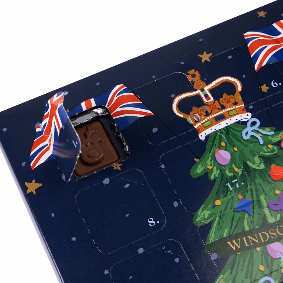 Door 1 open in the corner of the navy calendar, a moulded milk chocolate square in its foil tray beside the crown