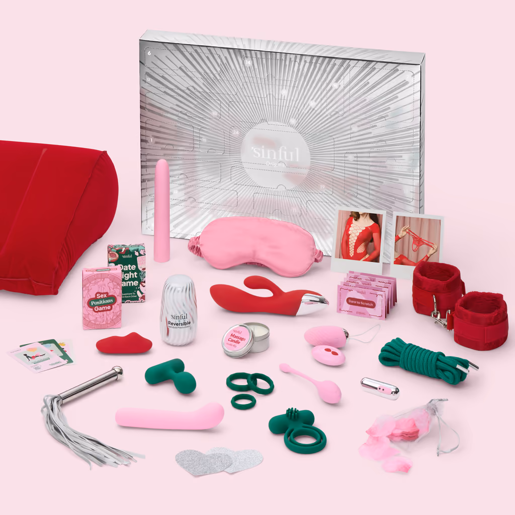 Every item laid out in front of the silver box, with the two card games, the cuffs and the wedge cushion