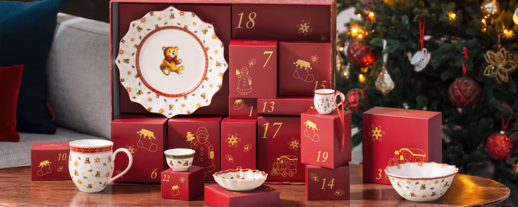 The Villeroy & Boch Christmas Toys 2026 advent calendar open on a table, numbered boxes and porcelain pieces in front of a Christmas tree